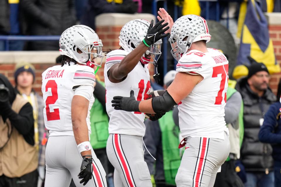 Nov 25, 2023; Ann Arbor, Michigan, USA; Ohio State Buckeyes wide receiver Marvin Harrison Jr. (18) celebrates a touchdown with wide receiver Emeka Egbuka (2) and offensive lineman Carson Hinzman (75) during the second half of the NCAA football game against the Michigan Wolverines at Michigan Stadium. Ohio State lost 30-24.