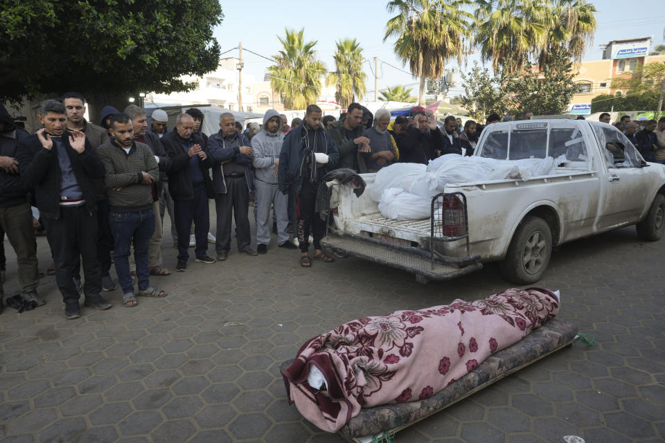 Palestinians mourn their relatives killed in the Israeli bombardment of the Gaza Strip in front of the morgue of Al Aqsa Hospital in Deir al Balah, Gaza Strip, on Tuesday, Jan. 2, 2024. (AP Photo/Adel Hana)