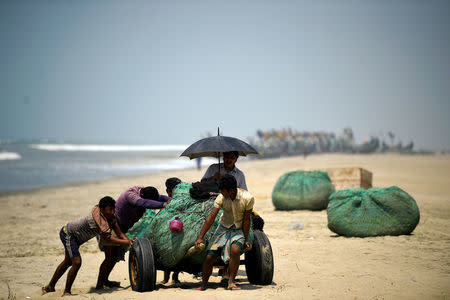 Rohingya refugees push fishing nets along the beach on Shamlapur beach in Cox's Bazaar, Bangladesh, March 22, 2018. REUTERS/Clodagh Kilcoyne