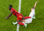 Belgium's Jeremy Doku, left, is tackled by Italy's Nicolo Barella during the Euro 2020 soccer championship quarterfinal match between Belgium and Italy at the Allianz Arena in Munich, Germany, Friday, July 2, 2021. (Stuart Franklin/Pool Photo via AP)