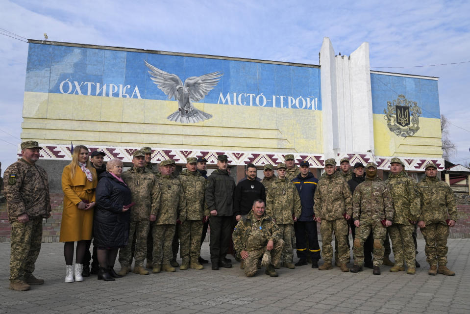Ukrainian President Volodymyr Zelenskyy poses for a photo with military personnel, police officers and civilians during a visit to Okhtyrka in the Sumy region of Ukraine, Tuesday March 28, 2023. (AP Photo/Efrem Lukatsky)