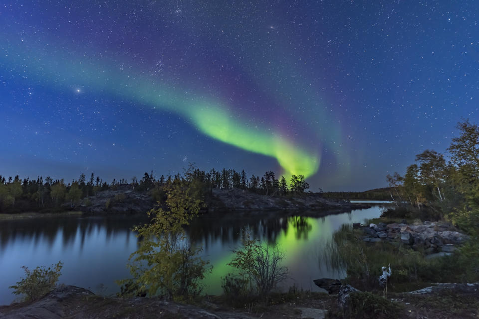 A display of Northern Lights starting up in the twilight, over the river leading out of Tibbitt Lake, at the end of the Ingraham Trail near Yellowknife NWT. (Photo by: VW Pics/Universal Images Group via Getty Images)