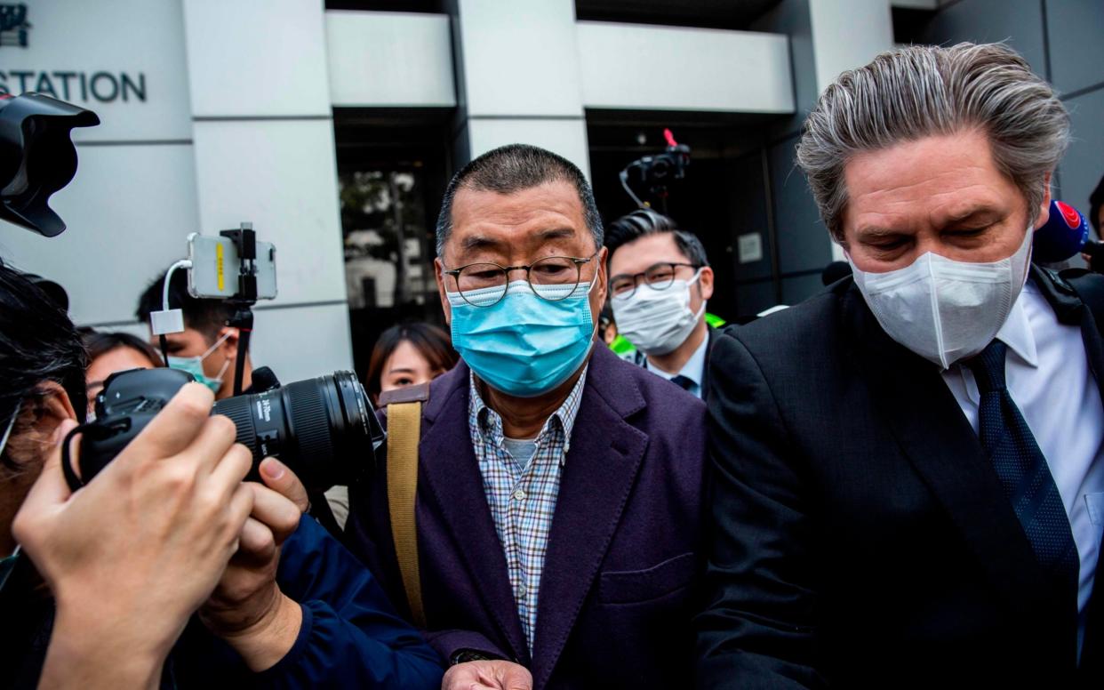 Hong Kong media tycoon and founder of Apple Daily newspaper Jimmy Lai (C) leaves the Kowloon City police station in Hong Kong - Isaac Lawrence /AFP