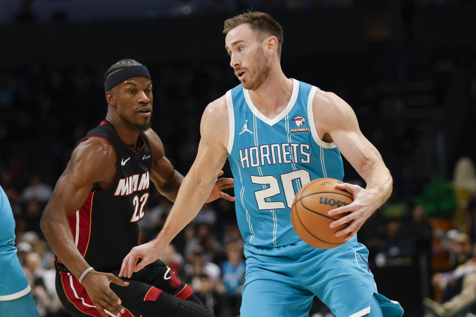 Charlotte Hornets forward Gordon Hayward (20) drives past Miami Heat forward Jimmy Butler during the first half of an NBA basketball game in Charlotte, N.C., Monday, Dec. 11, 2023. (AP Photo/Nell Redmond)