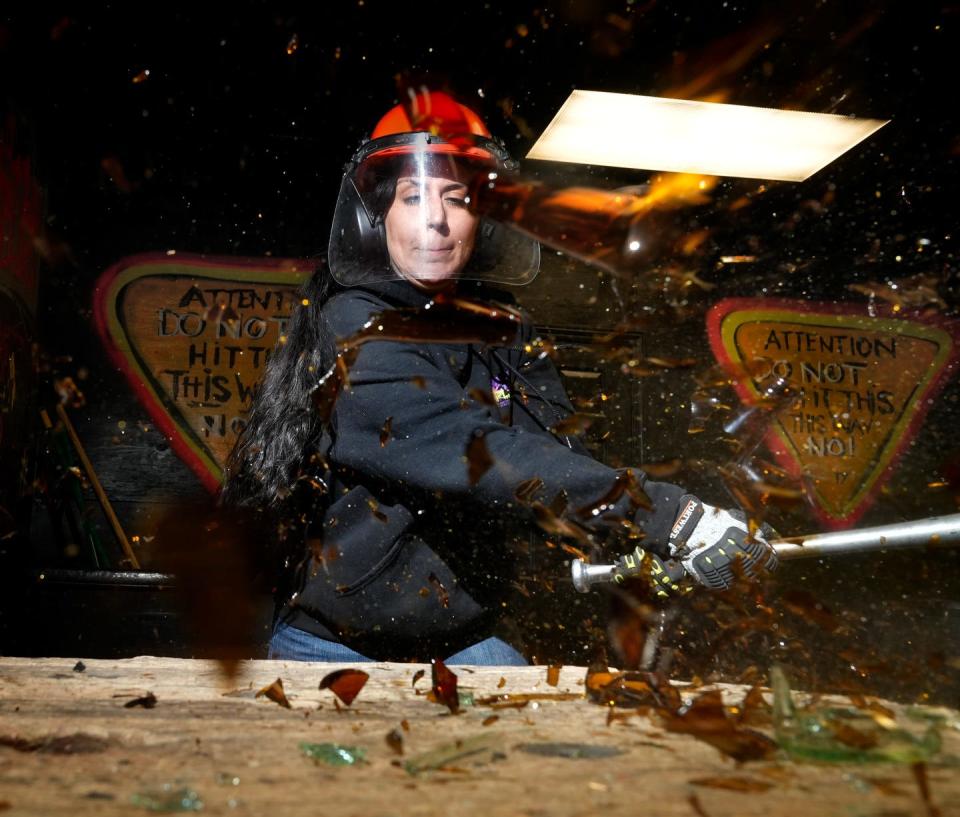 Samantha Rodriguez, owner of Smash n' Splash in West Warwick, shatters a glass bottles as she demonstrates how patrons can work out their rage/anger/frustration smashing things in her rage/smash room.  