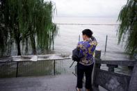 Man looks at the Tai Lake, which has flooded its banks following heavy rainfall, in Huzhou