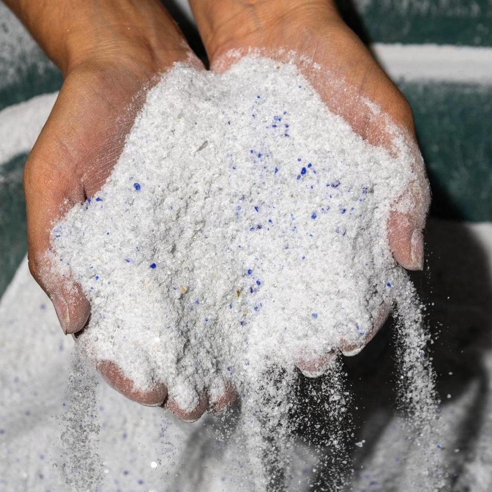 Glass For Life Co-Founder Paola Barranco holds the sand produced from processing glass bottles at the company’s warehouse on Tuesday, May 28, 2024, in Miami, Fla.