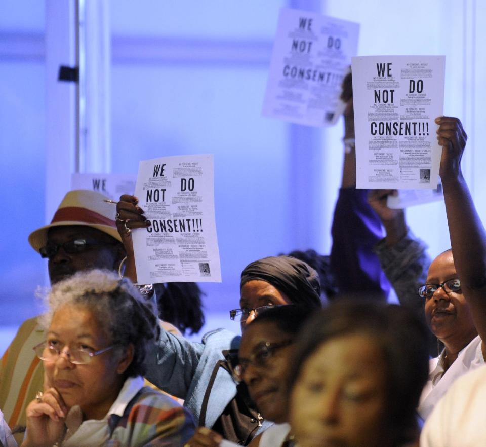 Audience members protest before the Detroit City Council during a special meeting in Detroit on Monday, June 11, 2012. Mayor Dave Bing and City Council members held a spirited debate Monday about the city's corporation counsel's decision to legally challenge the consent agreement, with the mayor warning the state will let the city run out of cash this week. Bing told City Council that state revenue sharing likely will be withheld unless a lawsuit challenging Gov. Rick Snyder's consent agreement with the city is dropped. (AP Photo/The Detroit News, David Coates) DETROIT FREE PRESS OUT; HUFFINGTON POST OUT