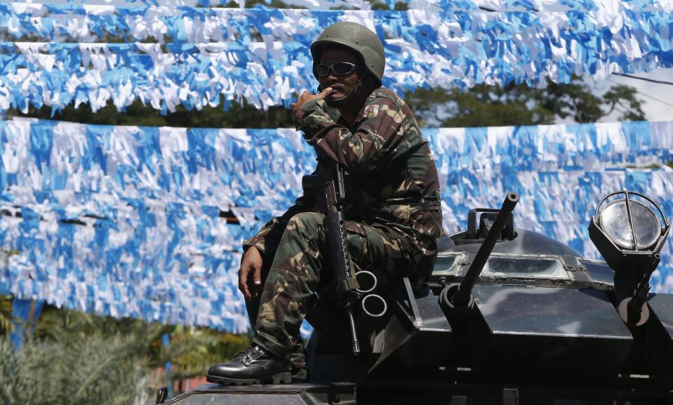 A government soldier sits on the turret of an armoured vehicle while securing a road on the fifth day of a government stand-off with the Moro National Liberation Front (MNLF) seeking an independent state in Zamboanga city, in southern Philippines September 13, 2013. Local government officials said evacuees have reached to about 20,000 people, as a government stand-off with the MNLF seeking an independent state reaches its fifth day. REUTERS/Erik De Castro (PHILIPPINES - Tags: CIVIL UNREST CONFLICT POLITICS MILITARY)