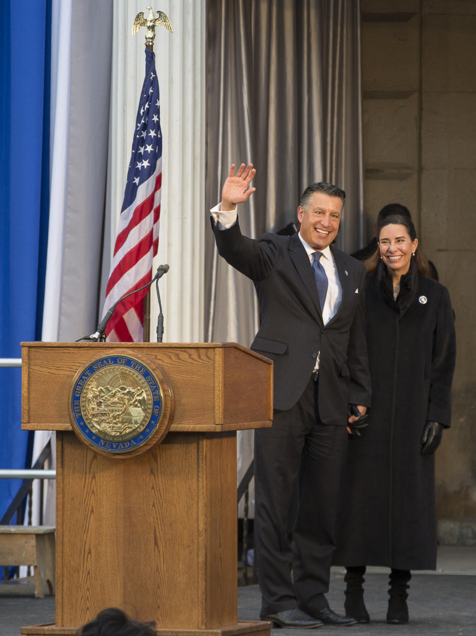 Governor Brian Sandoval, with wife Lauralyn McCarthy, gives one last wave as governor before Governor-elect Steve Sisolak is sworn into office on the steps of the Nevada State Capitol in Carson City, Nev., Monday, Jan. 7, 2019. (AP Photo/Tom R. Smedes)