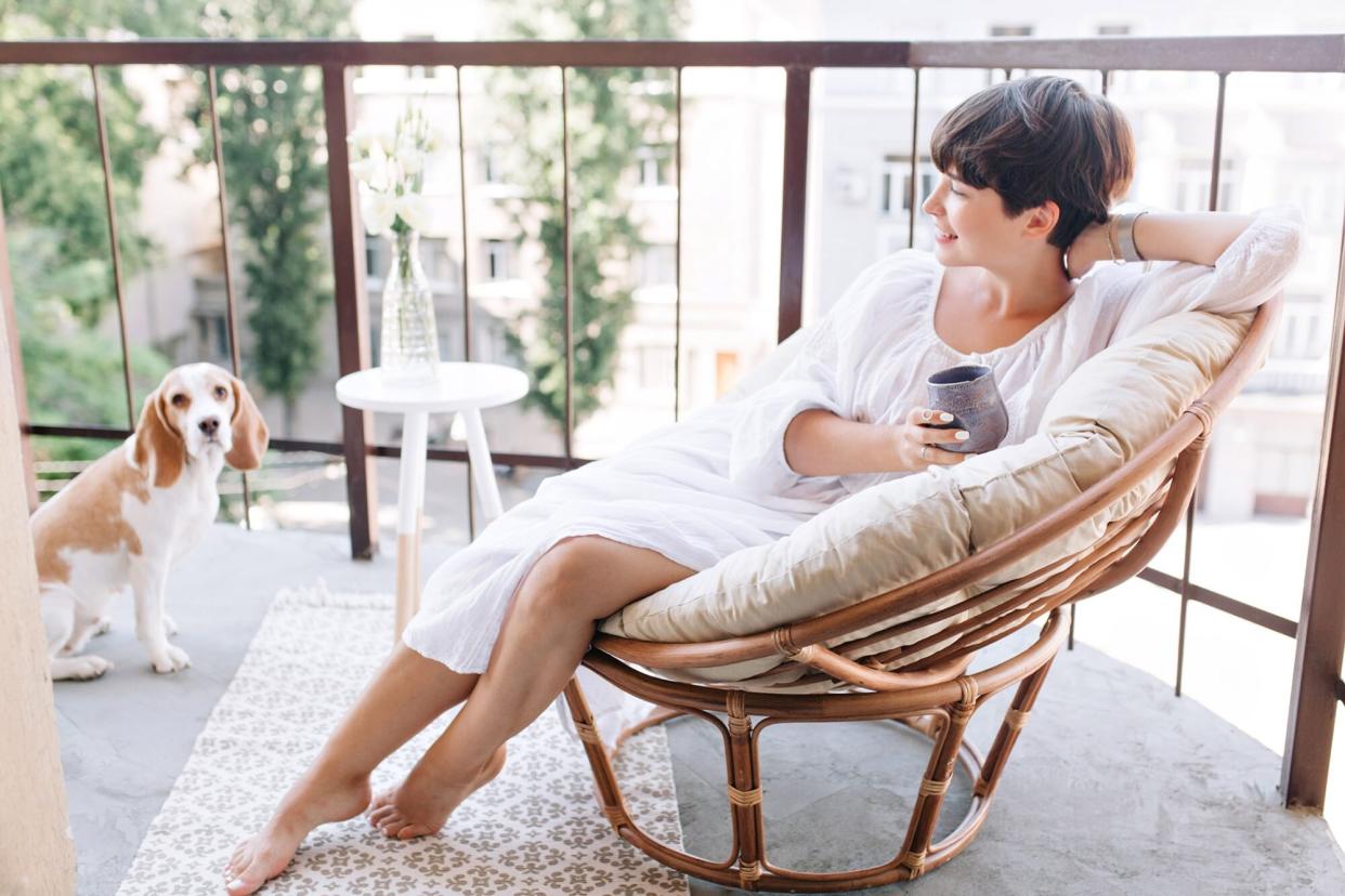 woman lounging on patio of airbnb with her dog