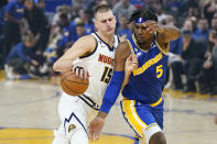 Denver Nuggets center Nikola Jokic (15) drives to the basket against Golden State Warriors center Kevon Looney (5) during the first half of an NBA basketball game in San Francisco, Friday, Oct. 21, 2022. (AP Photo/Jeff Chiu)