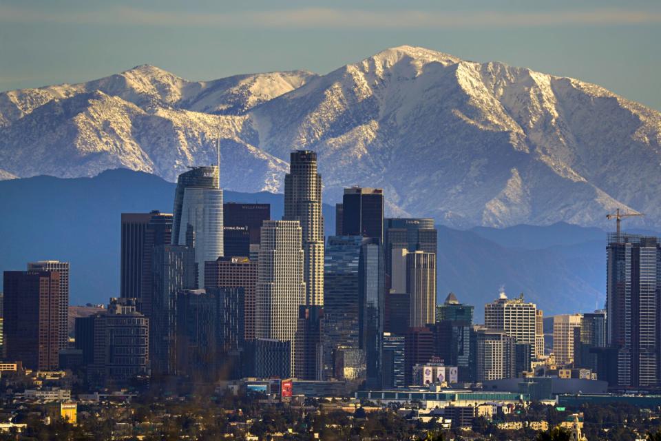 The downtown Los Angeles skyline against a backdrop of snow-covered mountains