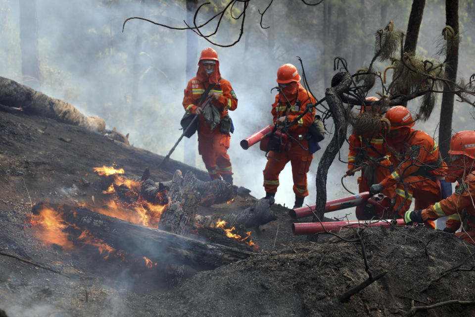 In this photo released by Xinhua News Agency, firefighters put out a forest fire in Xichang, in southwestern China's Sichuan Province, Tuesday, March 31, 2020. Nineteen people have died while fighting a raging forest fire in southwestern China and hundreds of reinforcements were sent to fight the blaze and evacuate nearby residents, officials and state media reported Tuesday. (Li Jieyi/Xinhua via AP)