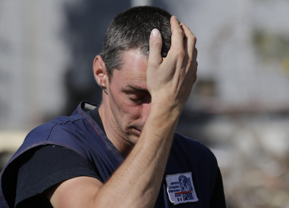 In this Friday, Oct. 5, 2018, file photo, a member of the French organization Pompiers de l'urgence wipes sweat from his forehead after checking for signs of life on their device at a heavily damaged Mercure hotel caused by the massive earthquake and tsunami in Palu, Central Sulawesi, Indonesia. (AP Photo/Aaron Favila, File)