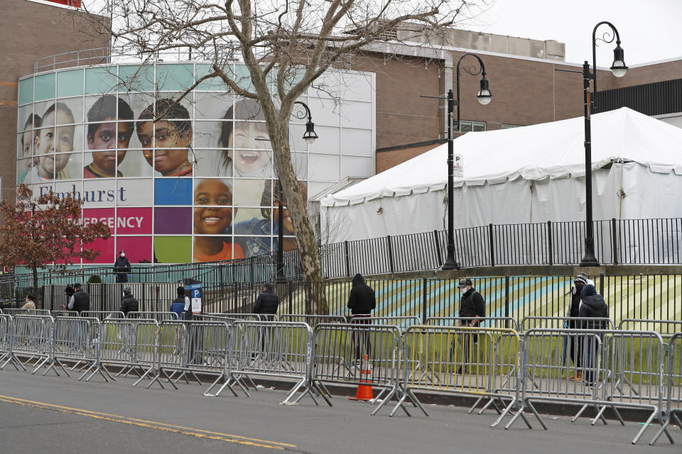 People waiting to be tested for COVID-19 line up with plenty of distance between themselves at Elmhurst Hospital Center in New York, Saturday, March 28, 2020. The hospital is caring for a high number of coronavirus patients in the city. (AP Photo/Kathy Willens)
