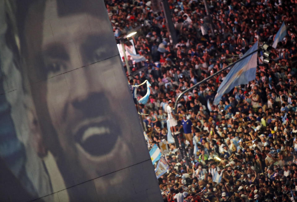 Soccer Football - FIFA World Cup Final Qatar 2022 - Fans in Buenos Aires - Buenos Aires, Argentina - December 18, 2022  Argentina fans celebrate winning the World Cup at the Obelisk with an image of Leo Messi REUTERS/Agustin Marcarian