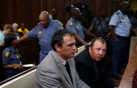 Farmers Willem Oosthuizen and Theo Martins wait to be led down to holding cells after being sentenced for kidnap, assault and attempted murder, in connection with forcing a man into a coffin, in Middelburg, South Africa, October 27, 2017. REUTERS/Siphiwe Sibeko