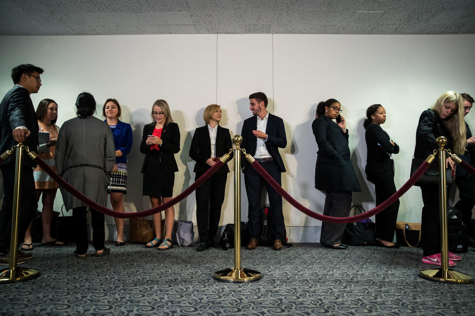 People wait in line outside the hearing room to attend Comey's testimony.