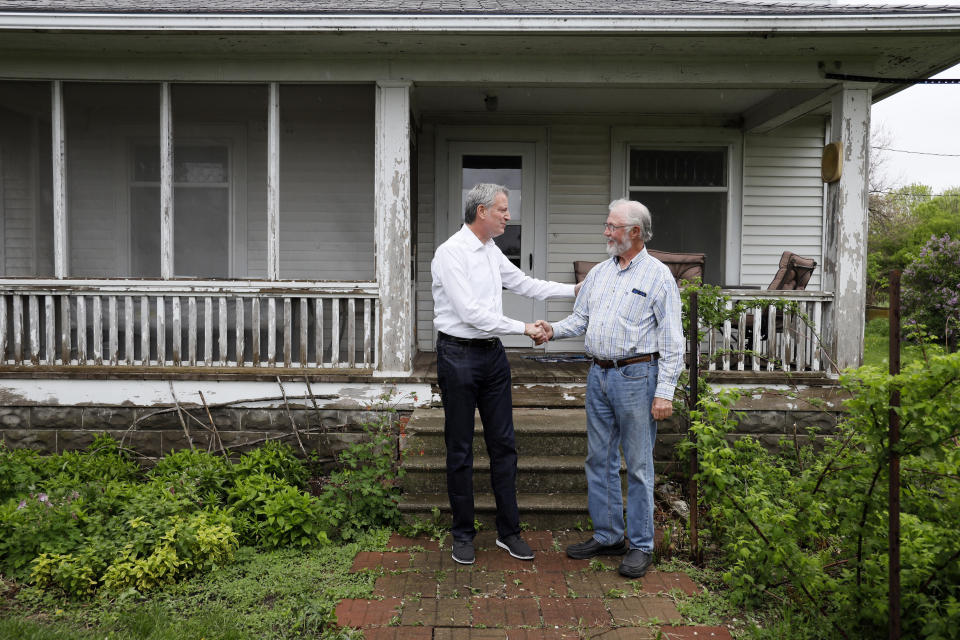 Democratic presidential candidate New York Mayor Bill de Blasio talks with George Naylor, right, after a meeting with Greene County small family farmers, Friday, May 17, 2019, in Churdan, Iowa. (AP Photo/Charlie Neibergall)