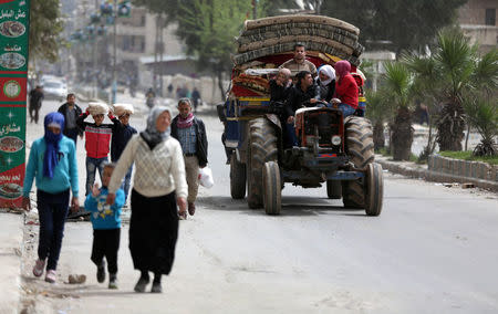 People ride on a tractor with their belongings in the center of Afrin, Syria March 24, 2018. REUTERS/Khalil Ashawi