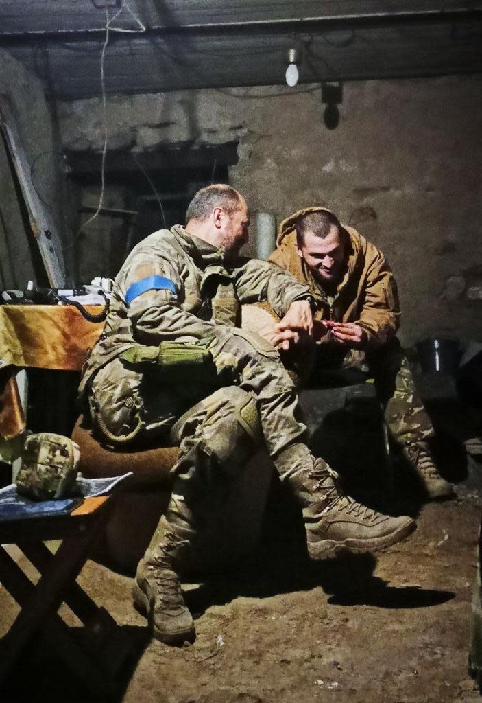Oleh Holubenko (L) and "Fanat," his counterpart in the 93rd Brigade, seated and chatting in a rough, concrete room with a mud floor.