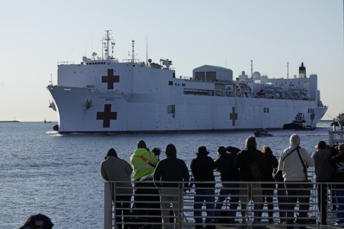 A crowd gathers to watch the arrival of the USNS Mercy hospital ship in San Pedro, Los Angeles