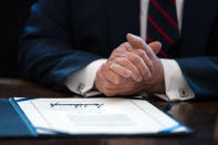 FILE - In this March 27, 2020, file photo President Donald Trump finishes signing the coronavirus stimulus relief package in the Oval Office at the White House in Washington. The 2020 presidential and Senate elections will likely take place as the world’s largest economy is still attempting to climb back from the deadly coronavirus outbreak. (AP Photo/Evan Vucci, File)