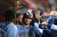 Toronto Blue Jays Cavan Biggio, center, celebrates in the dugout after scoring off of a single hit by Alejandro Kirk during the seventh inning of a baseball game against the Los Angeles Angels in Anaheim, Calif., Saturday, May 28, 2022. (AP Photo/Ashley Landis)