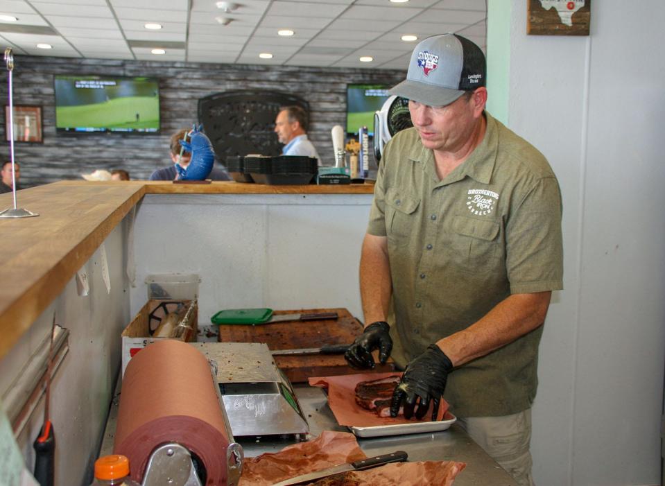 John Brotherton slicing barbecue at Brotherton's Black Iron Barbecue in Pflugerville.