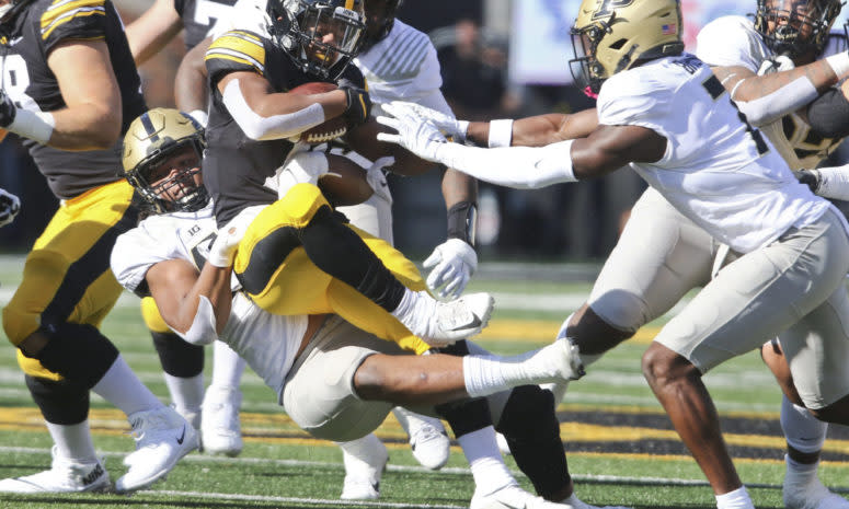 Iowa's running back is tackled by Purdue.