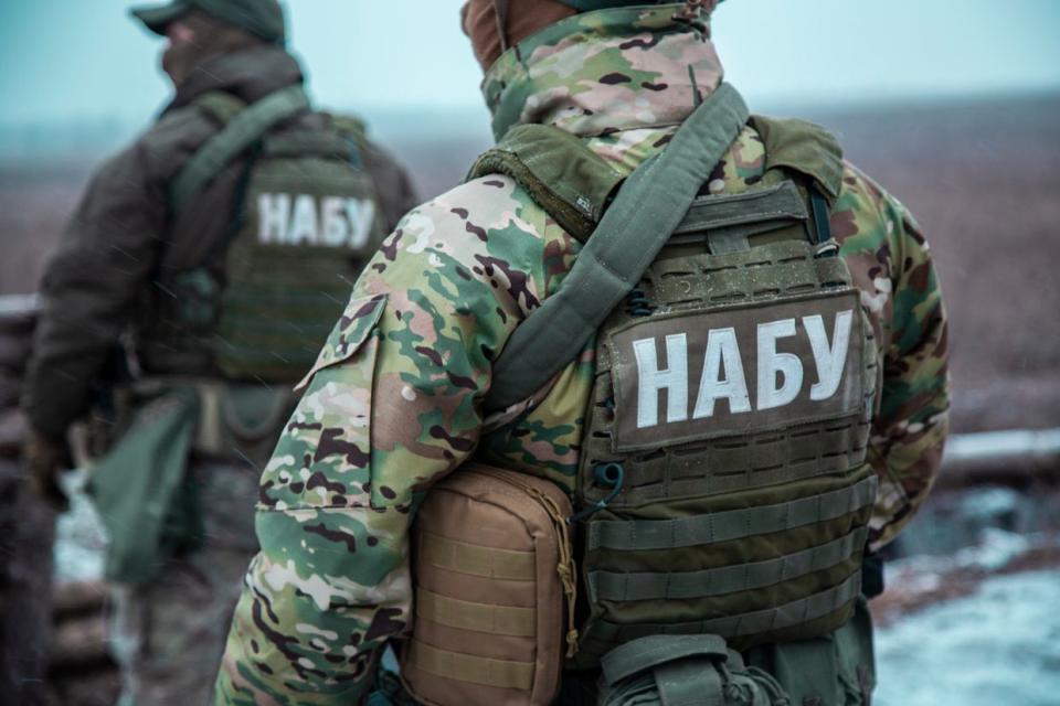 The employees of the National Anti-Corruption Bureau of Ukraine (NABU) are seen during work in an undated photograph. The protective vests they wear display the Ukrainian acronym "NABU." (facebook.com/nabu.gov.ua)