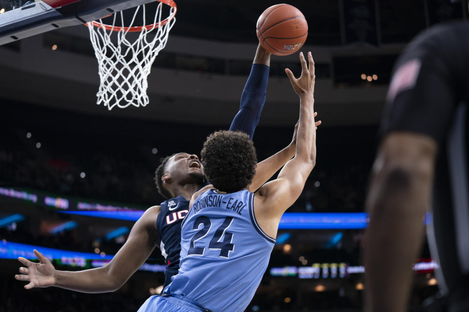 Connecticut's Josh Carlton, left, blocks the shot attempt by Villanova's Jeremiah Robinson-Earl, right, during the first half of an NCAA college basketball game Saturday, Jan. 18, 2020, in Philadelphia. (AP Photo/Chris Szagola)