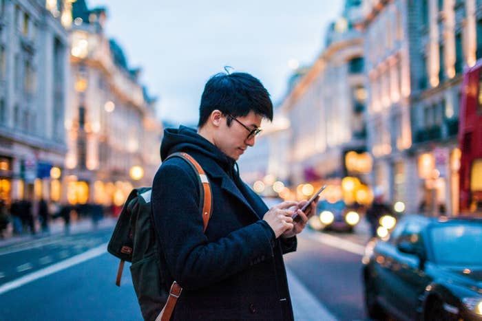 A man using his phone on the street