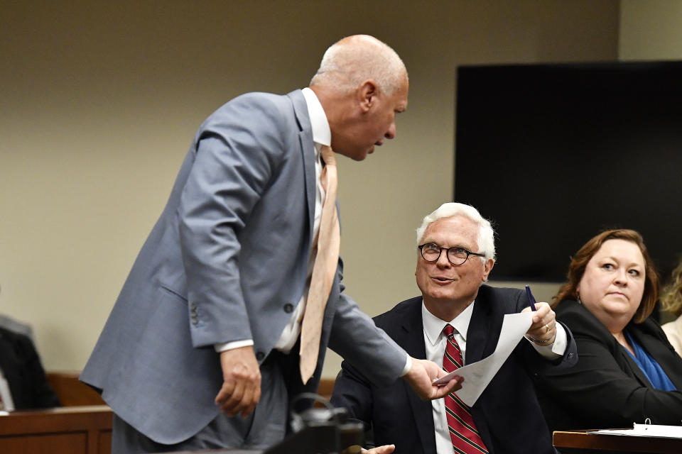 Jefferson County Attorney Mike O'Connell, right, hands a document to Steve Romines, attorney for golfer Scottie Scheffler before court proceedings at the Jefferson County Hall of Justice in Louisville, Ky., Wednesday, May 29, 2024. Criminal charges against Scottie Scheffler have been dismissed, ending a legal saga that began with images of the world’s top male golfer being arrested and handcuffed in Louisville during the PGA Championship. (AP Photo/Timothy D. Easley)