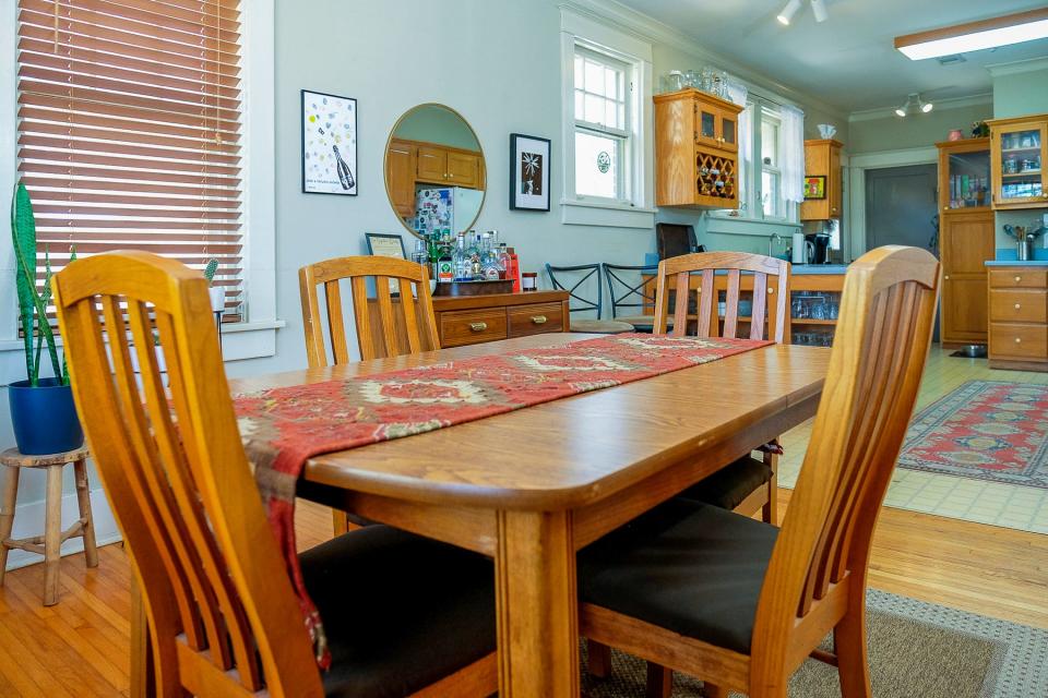 The dining area is adjacent to the kitchen. The wood tones of the furniture match well with the cabinetry.