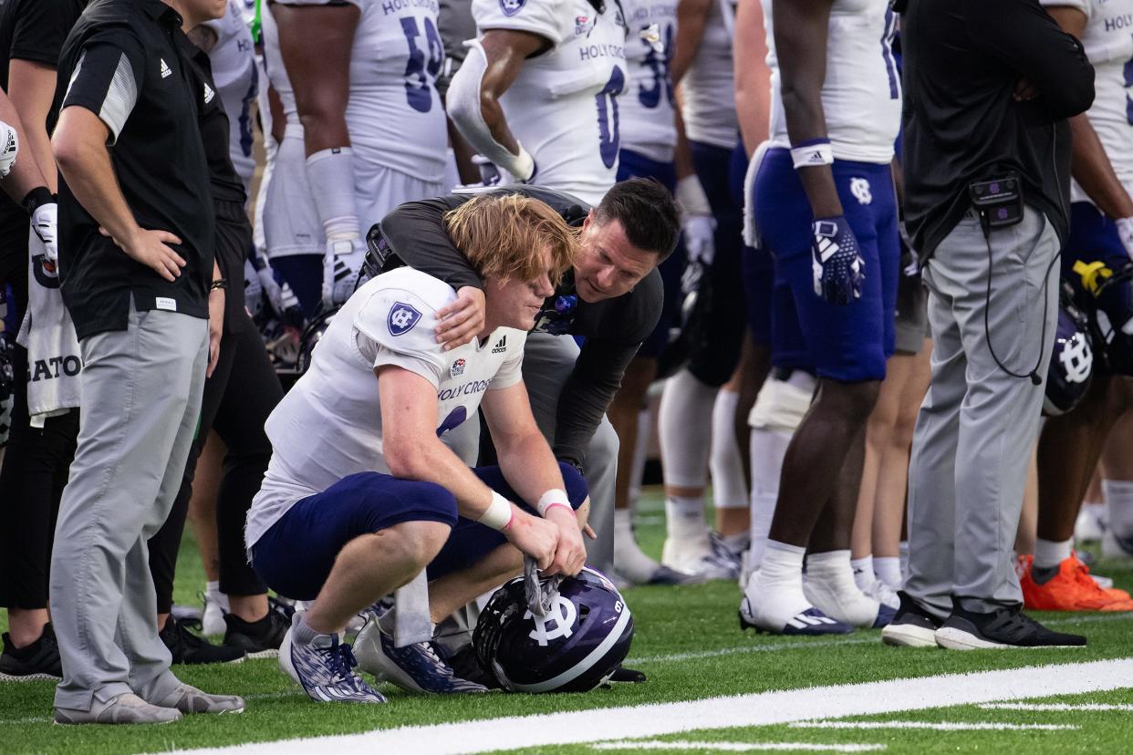 Holy Cross coach Bob Chesney consoles Matthew Sluka after he fumbled resulting in a turnover to Boston College and ending the game.