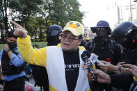 Protest leader Parit "Penguin" Chiwarak speaks to the media while wearing an outfit of a yellow duck, which has become a good-humored symbol of resistance during anti-government rallies, Wednesday, Nov. 25, 2020, in Bangkok, Thailand. Thai authorities have escalated their legal battle against the students leading pro-democracy protests, charging 12 of them with violating a harsh law against defaming the monarchy. (AP Photo/Sakchai Lalit)