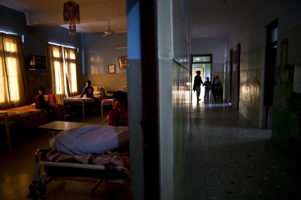 In this Sunday, Feb. 16, 2014, photo, a Pakistani nurse, right, helps a child to walk in a corridor, part of the patient daily treatment, while children, left, who live at St. Joseph’s Hospice, chat in a ward of the hospice, in Rawalpindi, Pakistan. Mohammed Aqeel spent weeks at home in Pakistan waiting for death after suffering a debilitating spinal cord injury in a car crash before friends suggested he come to St. Joseph’s Hospice on the outskirts of the capital, Islamabad. Now 13 years later, his life and those of some 40 others who live on its grounds might be changed forever as this hospital of last resort faces closure over its rising debts. (AP Photo/Muhammed Muheisen)