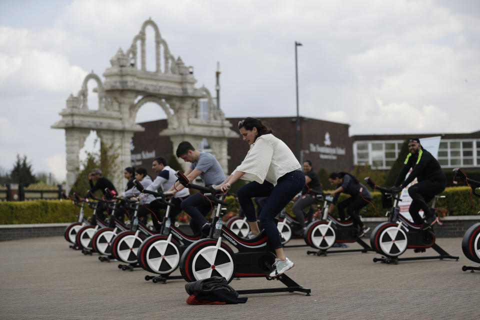 People take part in "Cycle to Save Lives" a 48 hour, non-stop static relay cycle challenge at the BAPS Shri Swaminarayan Mandir, also know as the Neasden Temple, the largest Hindu temple in the UK, in north London, to raise money to help coronavirus relief efforts in India, Saturday, May 1, 2021. The challenge sees people participating at three different venues in the UK, cycling in a static relay the equivalent distance of 7,600 Km, which is the distance from London to Delhi. (AP Photo/Matt Dunham)