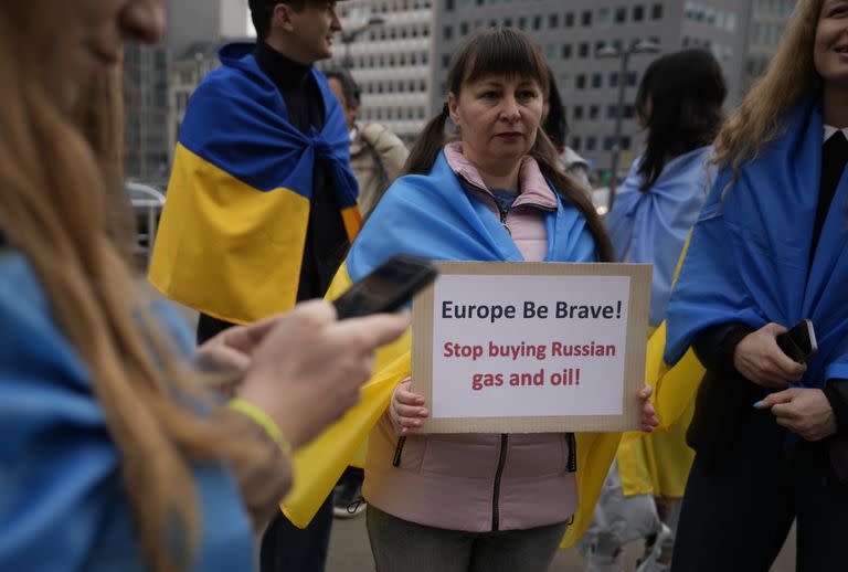 Una manifestante sostiene un cartel mientras participa en una manifestación para pedir a la Unión Europea que deje de comprar petróleo y gas ruso, frente a la sede de la UE en Bruselas, el viernes 29 de abril de 2022.