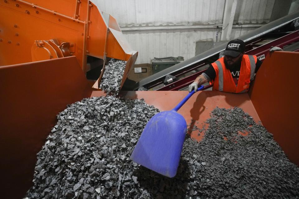 K.C. Skillern moves material with a shovel from recycled solar panels at We Recycle Solar on Tuesday, June 6, 2023, in Yuma, Ariz. North America’s first utility-scale solar panel recycling plant opened to address what founders of the company call a “tsunami” of solar waste, as technology that became popular in the early 2000s rapidly scales up. (AP Photo/Gregory Bull)