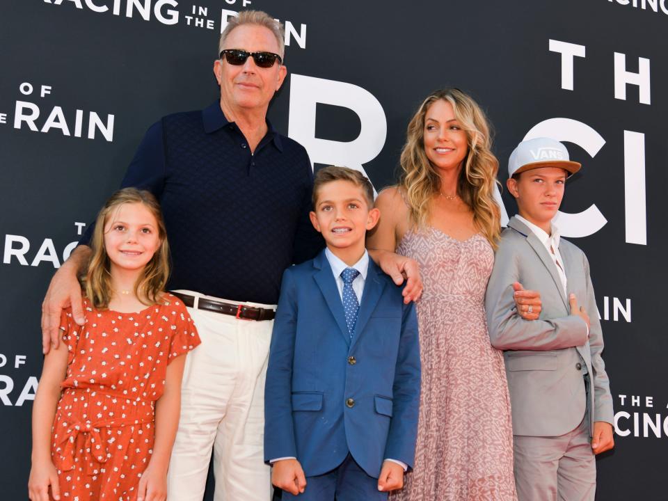 Kevin Costner, Christine Baumgartner, and their three children in 2019 being photographed at at event.