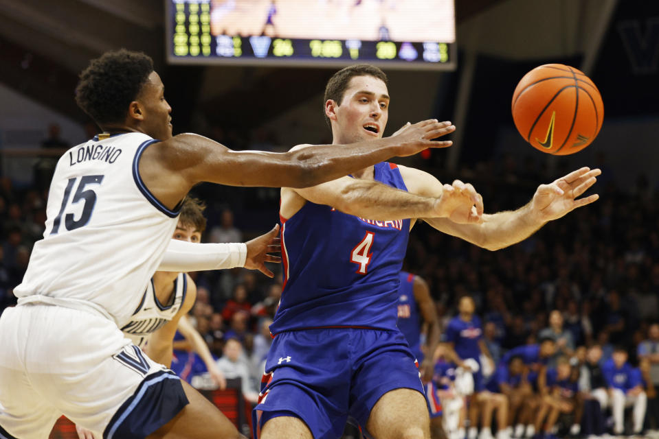 American guard Lincoln Ball (4) passes the ball away from Villanova guard Jordan Longino (15) during the first half of an NCAA college basketball game, Monday, Nov. 6, 2023, in Villanova, Pa. (AP Photo/Laurence Kesterson)