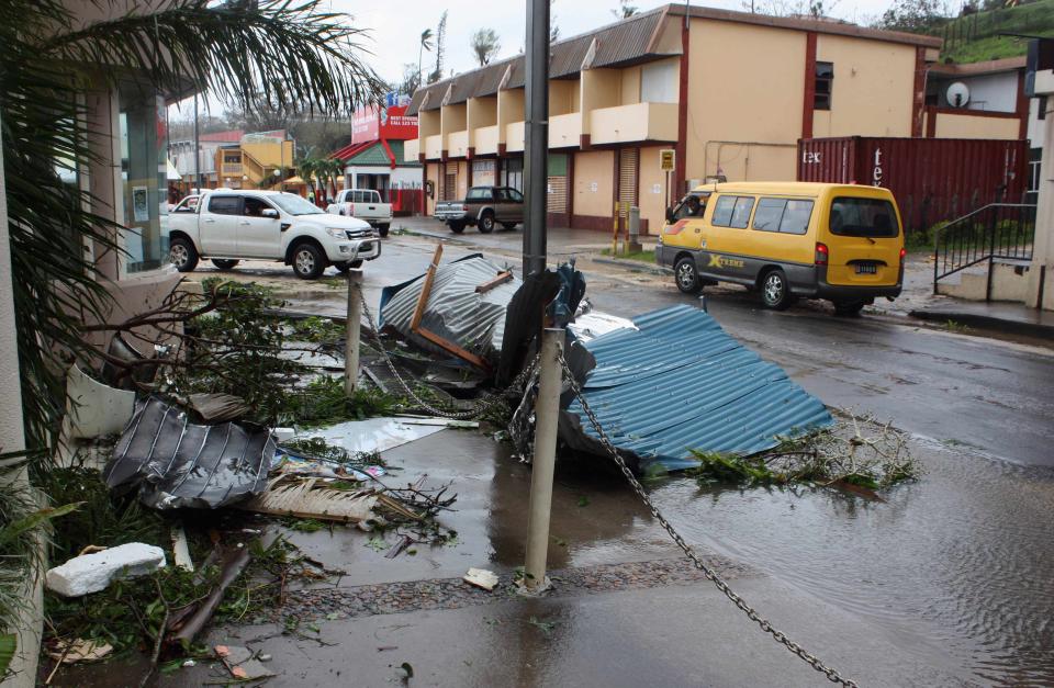 Debris lies in a street near damaged buildings in Port Vila