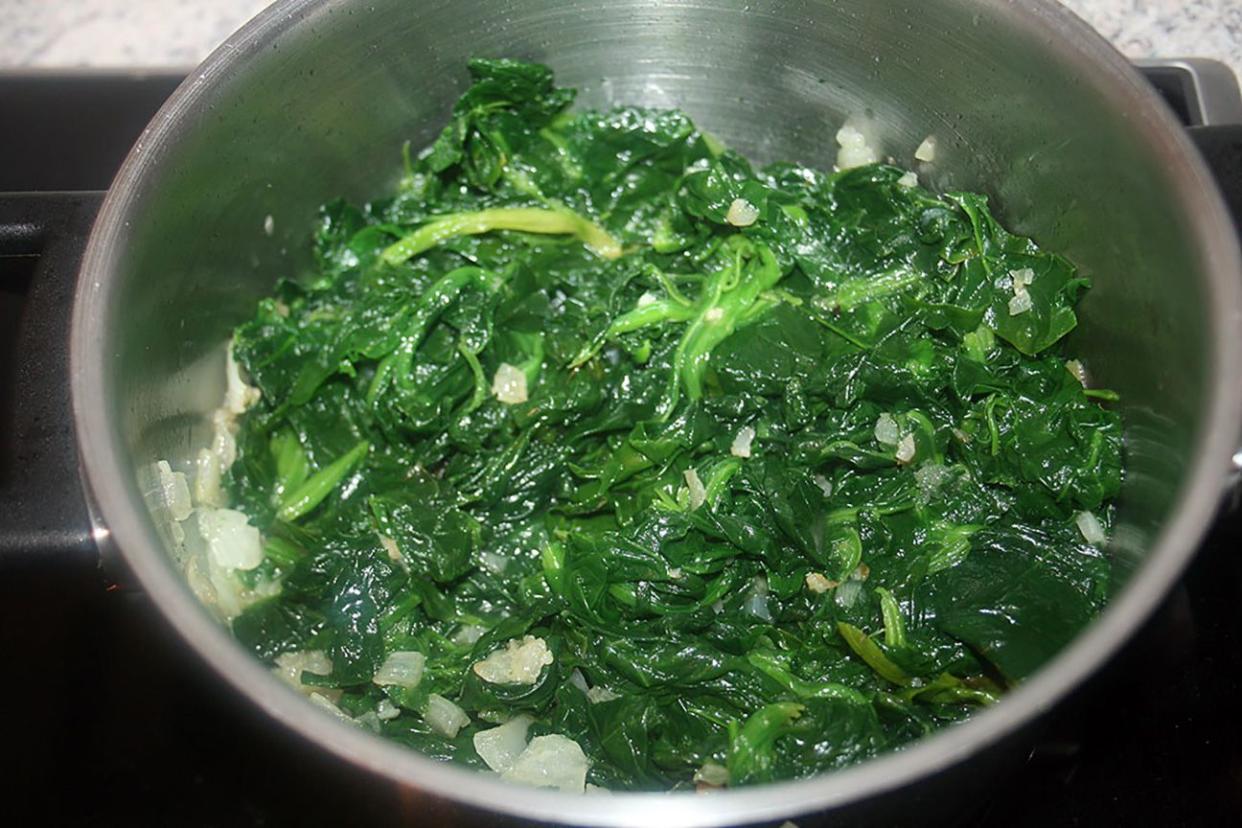 Cooked spinach in a metal bowl