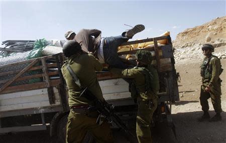 Israeli soldiers pull a Palestinian off a truck loaded with items European diplomats wanted to deliver to locals in the West Bank herding community of Khirbet al-Makhul, in the Jordan Valley September 20, 2013. REUTERS/Abed Omar Qusini