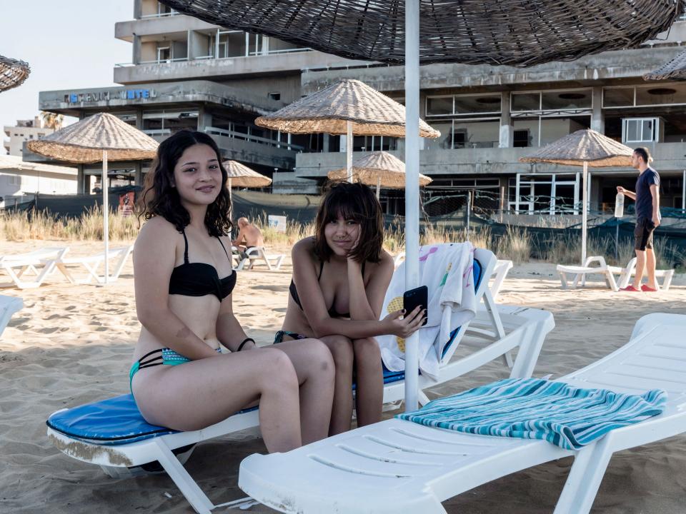 Tourists pose for a picture in the fenced-off area of Varosha in June 2021.