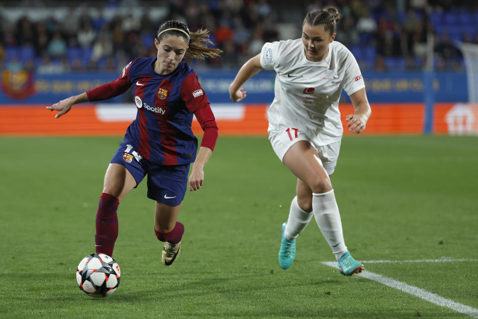 Barcelona's Aitana Bonmati, left, challenges for the ball with Brann's Anna Nerland Aahjem during the women's Champions League quarterfinals, second leg, soccer match between FC Barcelona and SK Brann Kvinner at the Estadi Johan Cruyff in Barcelona, Spain, Thursday, March 28, 2024. (AP Photo/Joan Monfort)