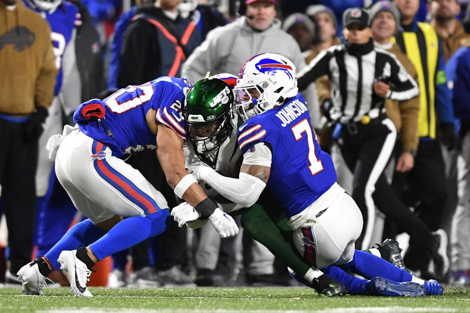 New York Jets running back Breece Hall, center, is tackled by Buffalo Bills safety Taylor Rapp (20) and Taron Johnson (7) during the first half of an NFL football game in Orchard Park, N.Y., Sunday, Nov. 19, 2023. Rapp was injured on the play and was taken off the field in an ambulance. (AP Photo/Adrian Kraus)